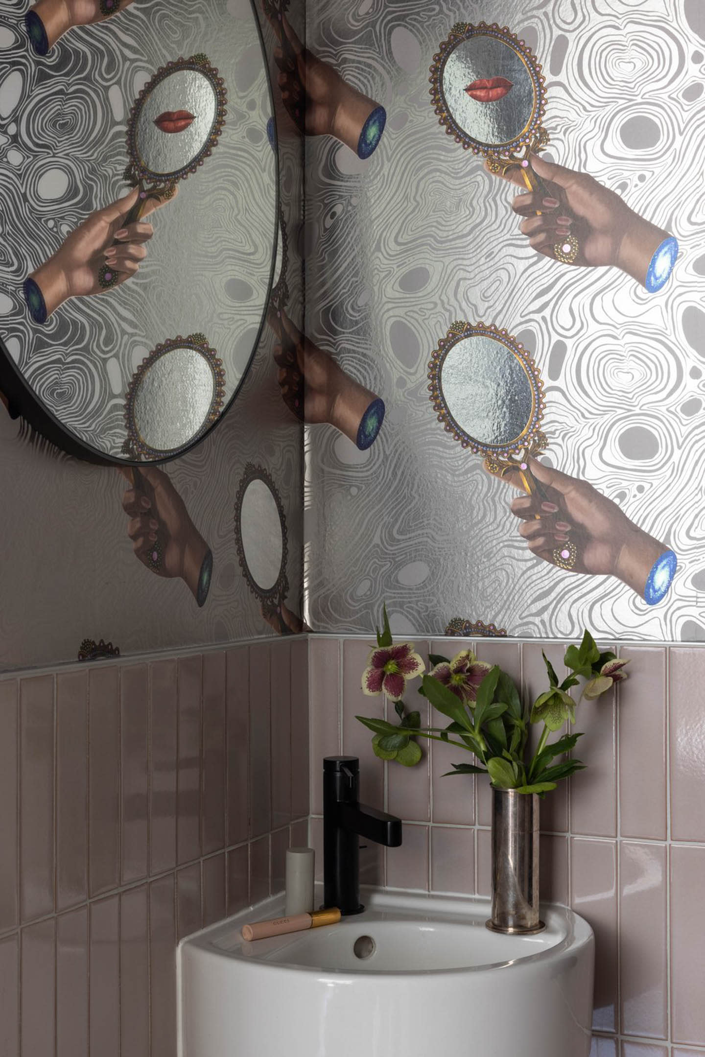 powder room with pink tile and funky wallpaper