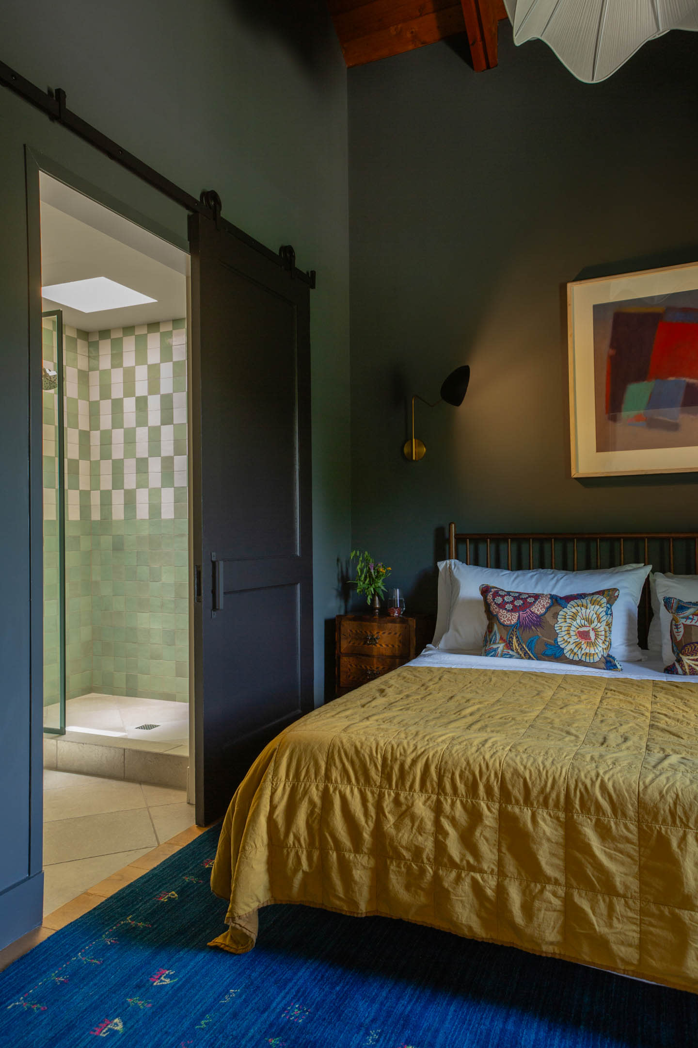 jewel tone bedroom with yellow linens, blue flooring and green walls