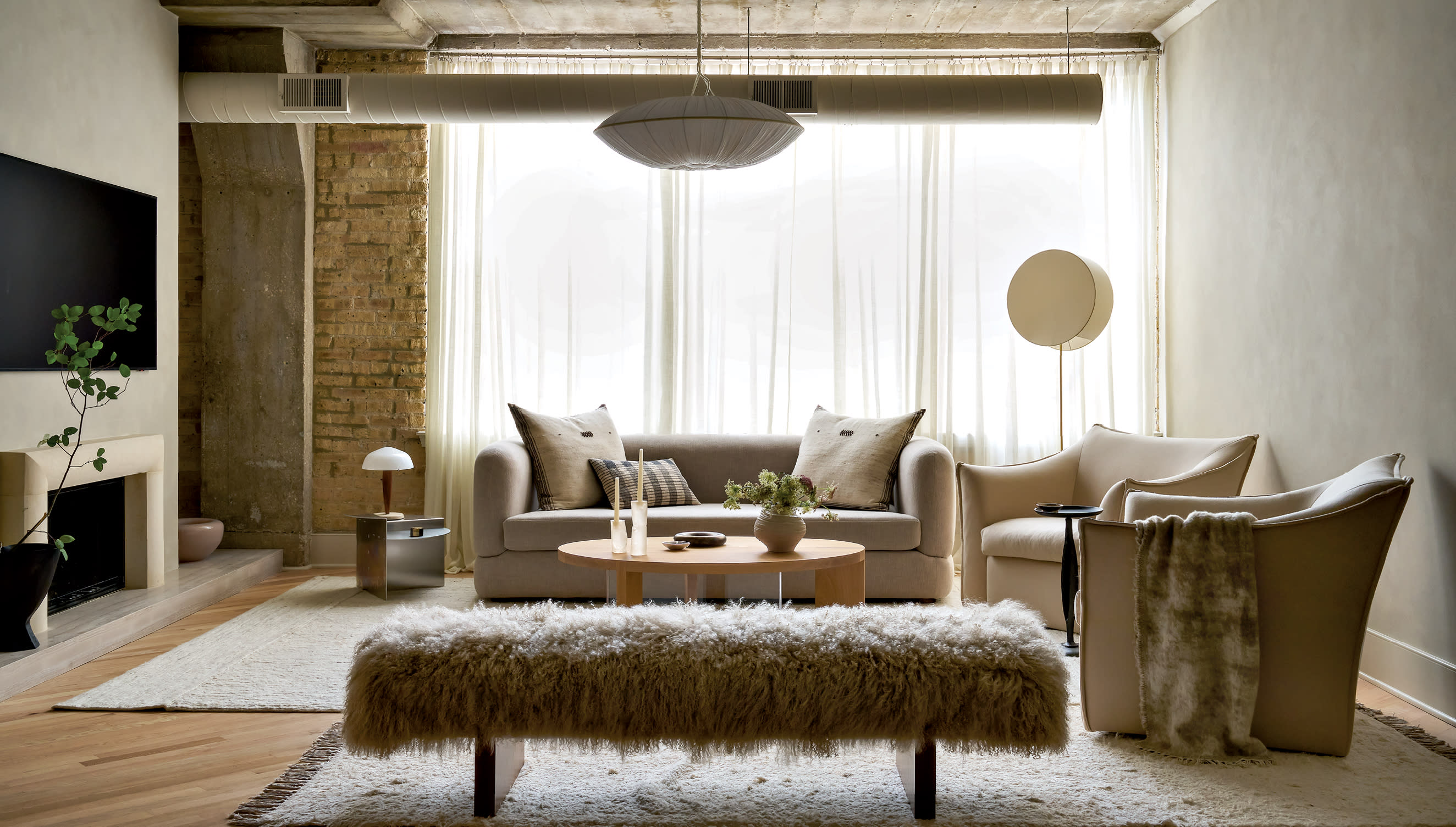organic modern living room with beige sofa and armchairs and a textured bench