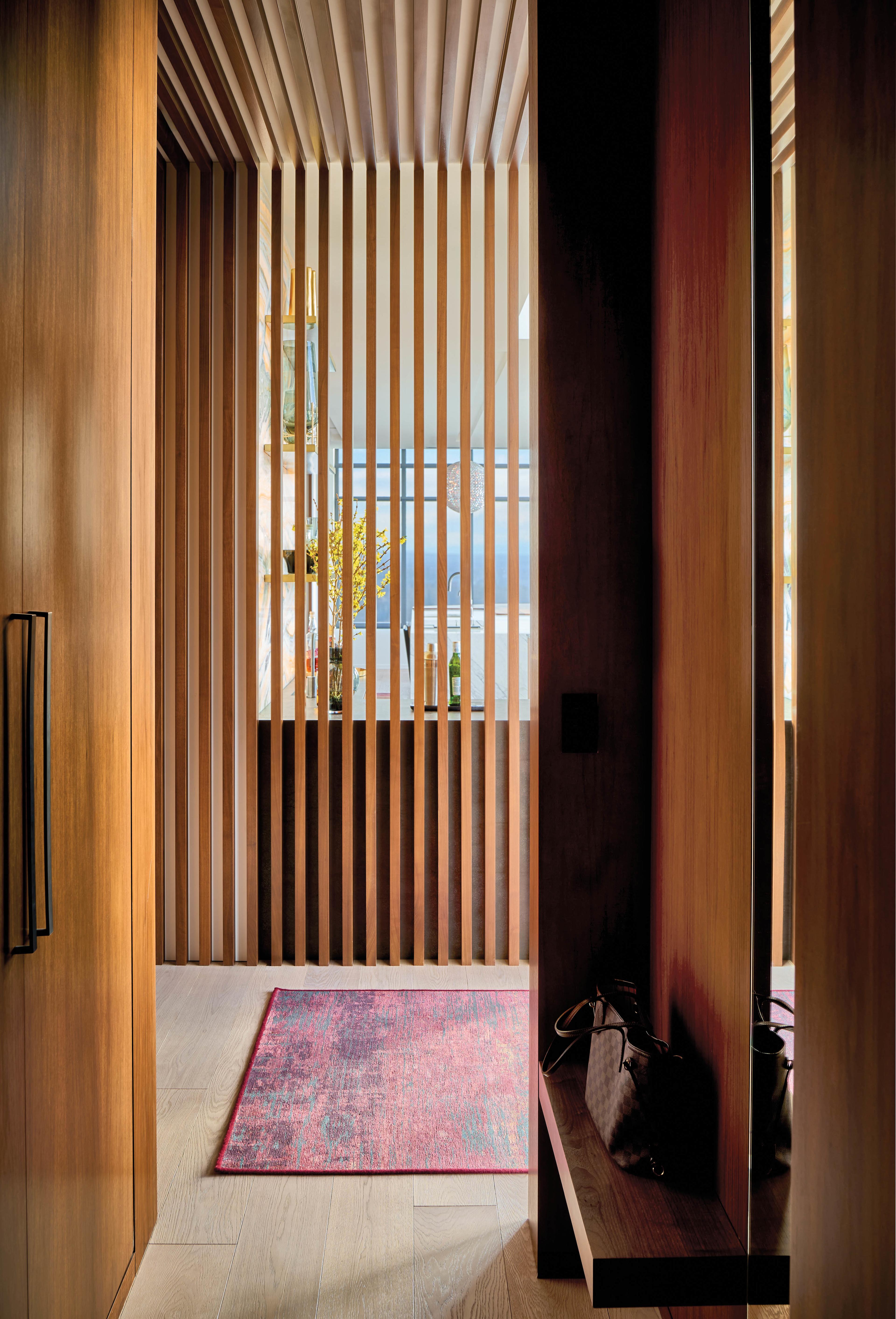 walnut slats form a partition in this home's hallway